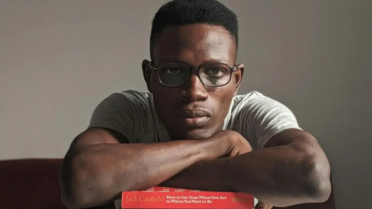 man on posing on top of jack canfield book